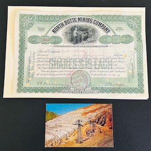 May include: An antique North Butte Mining Company stock certificate with green and black details, and a vintage postcard depicting a mining landscape. The certificate is on a cream-colored envelope.