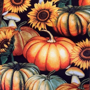 May include: A fabric pattern featuring sunflowers, pumpkins, and mushrooms in shades of orange, yellow, and green against a dark background. The design evokes a fall harvest theme, with detailed illustrations of the seasonal elements.