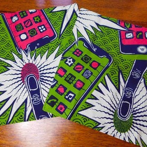 Puede incluir: Un tejido textil con un patrón repetitivo de teléfonos inteligentes estilizados en rosa y verde con dedos azul oscuro tocando las pantallas. El fondo es de un verde vibrante con un patrón ondulado y grandes formas de estrellas blancas.