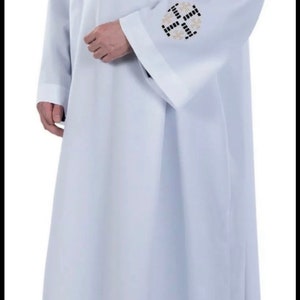 May include: A white liturgical robe with black and gold embroidered crosses on the sleeves and hem.
