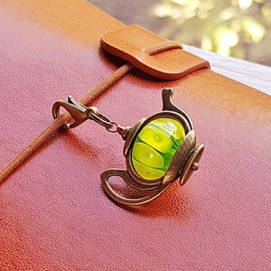 Planner charm with dangle bronze tone teapot and glass bead in yellow and green, Handmade lampwork glass pendant