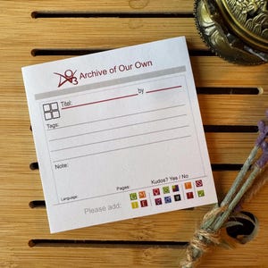 Könnte beinhalten: Eine weiße Karte mit dem Text "Archive of Our Own" und einem Logo. Die Karte hat Felder für Titel, Tags, Notizen, Sprache, Seiten und Kudos. Es gibt auch Symbole für verschiedene Arten von Inhalten.