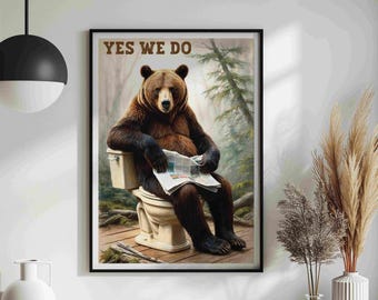 Può includere: Un orso bruno seduto su un water bianco con un giornale nelle zampe. Il testo "YES WE DO" è stampato sopra l'orso. L'orso si trova in un ambiente boschivo.