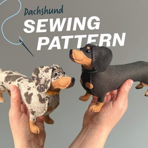 Pode incluir: Dois brinquedos de pelúcia de dachshund feitos à mão em feltro com um design de padrão de costura. Um cão tem um padrão manchado bege e preto, enquanto o outro é preto e bege sólido. O texto "Dachshund SEWING PATTERN" aparece em branco e azul.