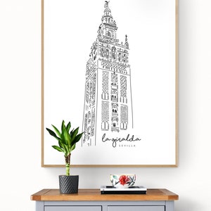 Può includere: Un disegno in bianco e nero della torre della Giralda a Siviglia, Spagna. Il disegno è incorniciato e appeso a una parete bianca sopra una cassettiera grigia.