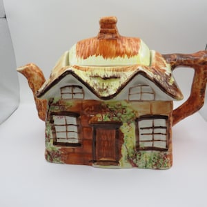 May include: A set of three ceramic mugs with a speckled, matte finish in cream, light brown, and dark brown. Each mug has a simple design and a rounded handle.
