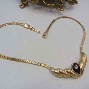 gorgeous vintage chunky gold tone statement necklace with a meet me in the middle pendant, decorated with black enamel and a .......