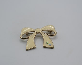 lovely vintage gold tone bow brooch with cream enamel and aurora borealis rhinestones, lovely condition, 4.5 by 3.5 cm measurements
