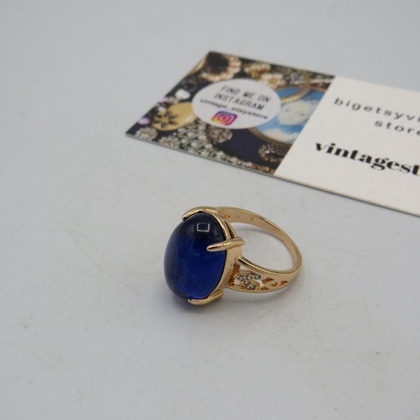 stunning gold tone statement cocktail ring with a large blue glass cabochon and clear rhinestones on the shoulder detailing..........