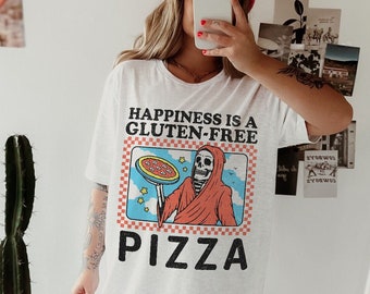 May include: White t-shirt with a graphic of a skeleton holding a pizza and the text "Happiness is a Gluten-Free Pizza".