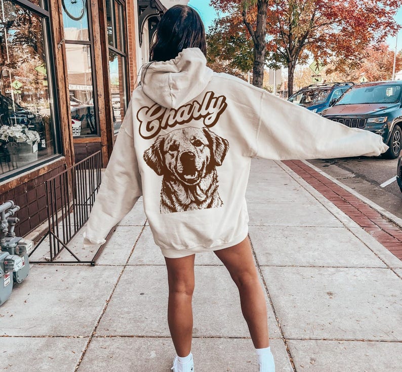May include: A cream-colored hoodie with a brown graphic of a dog and the word "Charly" in a retro font.