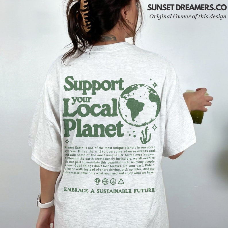 Peut inclure: Un t-shirt gris clair avec un imprim&eacute; graphique vert de la Terre et le texte "Support Your Local Planet". Le texte sous le graphique dit "Planet Earth is one of the most unique planets in our solar system. It has the will to overcome adverse events and sustain some of the most unique life forms ever known. Although the earth seems nearly invincible, we all need to do our part to maintain this beautiful rock. As many people know, Good things don't last forever. Do your part. Ride a bike or walk instead of short driving, pick up litter, dispose less waste, take only what you need and enjoy what we have. Embrace a Sustainable Future."