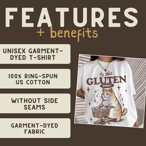May include: White unisex t-shirt with a graphic of a cat pushing a shopping cart, and the text "Is this Gluten Free?". The shirt also features the text "Features + benefits" and other text about the shirt's features.