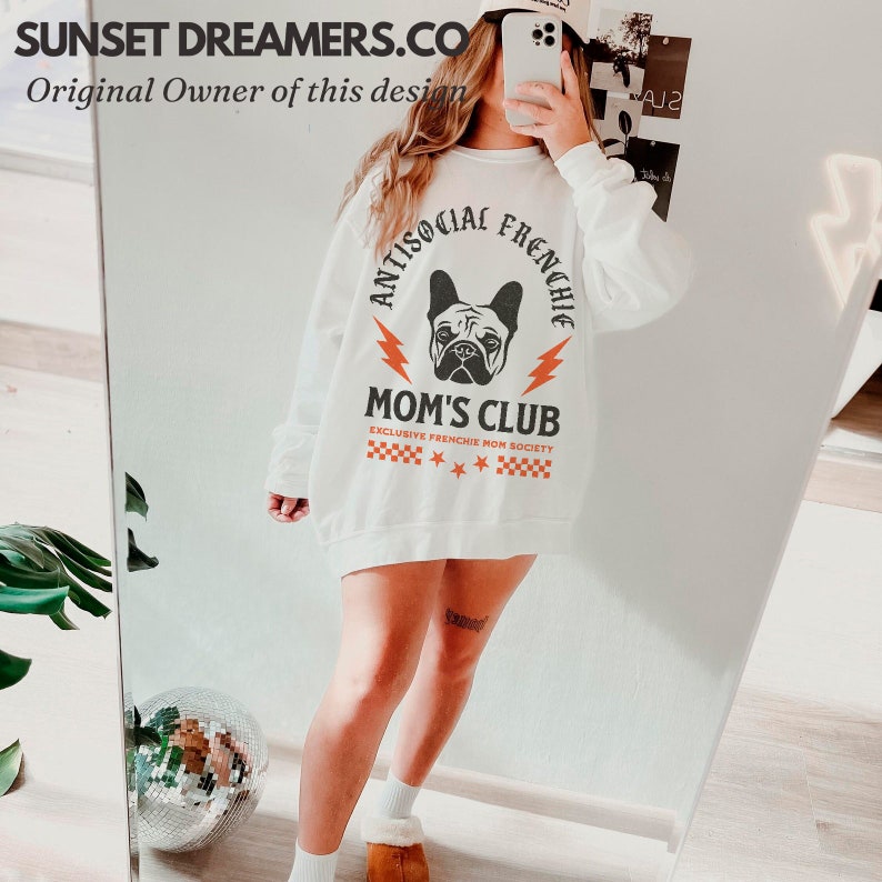 May include: White sweatshirt with a graphic of a French bulldog and the text "Antisocial Frenchie Mom's Club Exclusive Frenchie Mom Society".