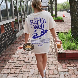 May include: A white t-shirt with a blue graphic of the Earth with a heart in the center and the text "Treat the Earth Well". The shirt also has the text "Together, we can make a difference" and a logo that says "Sunset Dreamers.Co Original Design".
