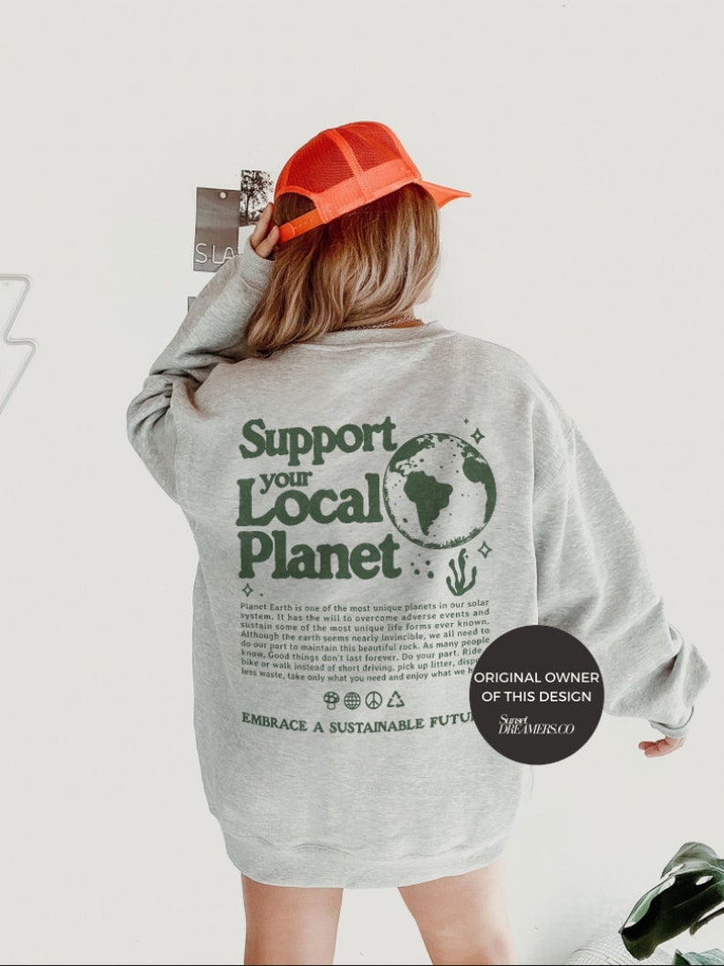 Puede incluir: Sudadera gris con un estampado gr&aacute;fico verde de la Tierra y el texto "Support Your Local Planet". El texto debajo del gr&aacute;fico dice: "Planet Earth is one of the most unique planets in our solar system, it has the will to overcome adverse events and sustain some of the most unique life forms ever known. Although the earth seems nearly invincible, we all need to do our part to maintain this beautiful rock. As many people know, Good things don't last forever. Do your part, Ride a bike or walk instead of short driving, pick up litter, dispose less waste, take only what you need and enjoy what we have. Embrace a Sustainable Future". La parte inferior del gr&aacute;fico dice "Original Owner of this Design Sweet Dreamers Co."