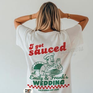 May include: White t-shirt with the text "I got sauced" in red, a chef graphic, and "Emily & Frank's WEDDING" in green. The bottom has a red and white checkered pattern and "CALIFORNIA-SEP-2025".