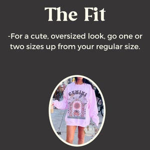 Puede incluir: Una sudadera rosa con un estampado gr&aacute;fico de un signo del zod&iacute;aco, la palabra "GEMINI" y el texto "CONSTELLATION OF TWINS".