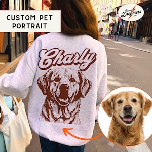 May include: A white sweatshirt with a brown dog illustration and the name "Charly" printed on the back. The dog is a golden retriever with a brown nose and brown eyes. The sweatshirt is a custom pet portrait.