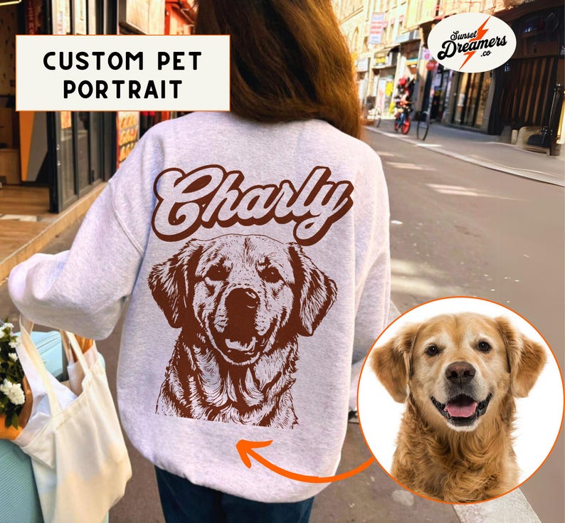 May include: A white sweatshirt with a brown dog illustration and the name "Charly" printed on the back. The dog is a golden retriever with a brown nose and brown eyes. The sweatshirt is a custom pet portrait.
