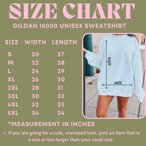 May include: Size chart for a Gildan 18000 unisex sweatshirt. The chart shows the width and length measurements in inches for sizes S through 5XL. The chart is on a green background with pink text. A white sweatshirt is shown on the right side of the chart.