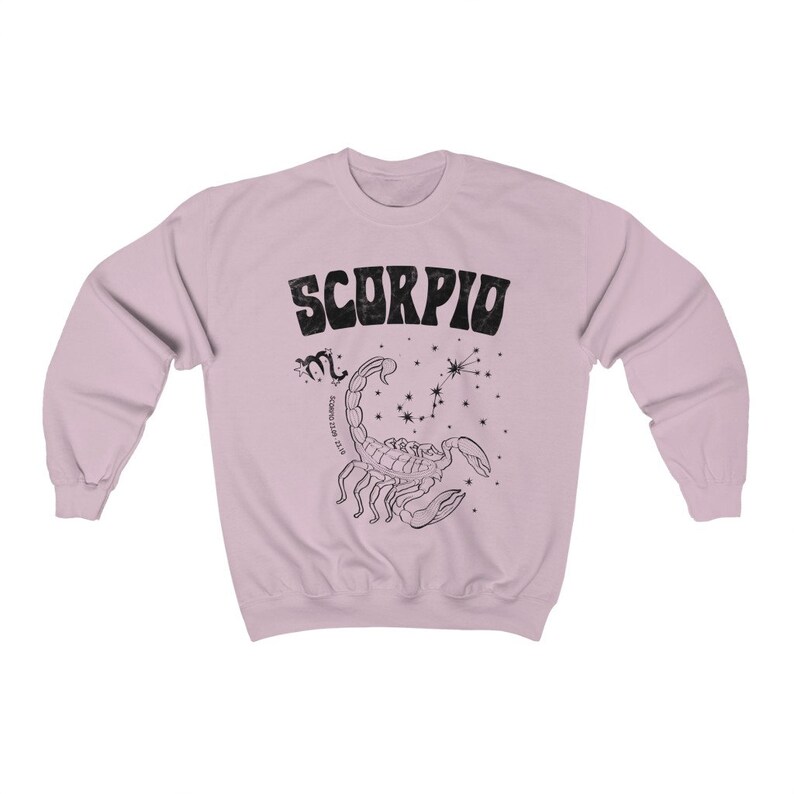 May include: A light pink sweatshirt with a black graphic print of a scorpion and the word "SCORPIO" in a retro font.