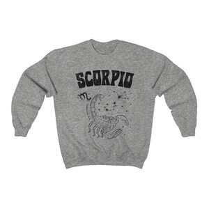 May include: Gray sweatshirt with a black graphic of a scorpion and the word "SCORPIO" in a retro font.