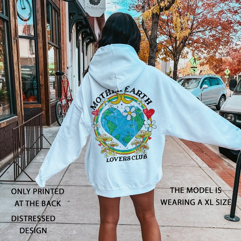 May include: White hoodie with a distressed design featuring a graphic of a heart-shaped Earth with the text "Mother Earth Lovers Club" printed on the back.