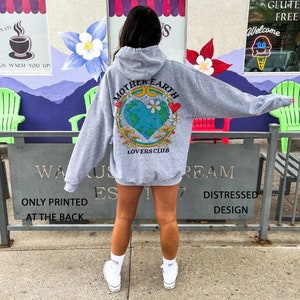 May include: Gray hooded sweatshirt with a graphic print of a colorful Earth with the text "Mother Earth Lovers Club" on the back.