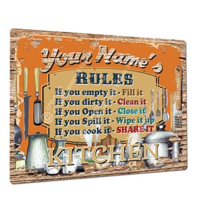 Puede incluir: Un letrero de metal naranja rústico con el texto "Your Name's Rules" y una lista de reglas de cocina: "If you empty it - Fill it", "If you dirty it - Clean it", "If you Open it - Close it", "If you Spill it - Wipe it up", "If you cook it - SHARE IT". El letrero también presenta una variedad de utensilios de cocina y utensilios de cocina.
