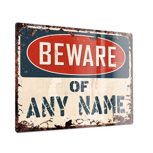 May include: A vintage-style metal sign with a red circle and white text that reads "BEWARE OF ANY NAME". The sign has a distressed, rusty look and is perfect for adding a touch of whimsy to any space.