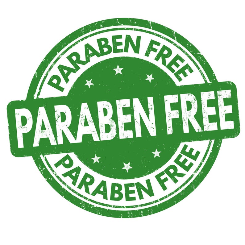 May include: Green round stamp with the text "PARABEN FREE" in white lettering. The text is repeated around the edge of the stamp.