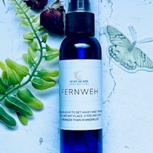 May include: A blue glass bottle with a spray nozzle, labeled "Fernweh" and "The urge to get away and travel to a distant place, a feeling stronger than wandering lust."