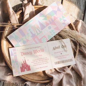 May include: A Disney World ticket and matching patterned card. The ticket is light pink with text that reads "Admit One" and "December 15, 2025". The card has a colorful geometric design.