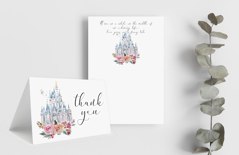 May include: White folded thank you cards with a watercolor castle design, surrounded by pink and red flowers. One card has the words "thank you" in black script. The other card has the text "Once in a while...fairy tale."