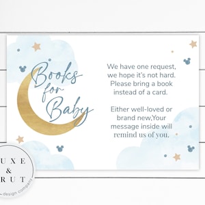 May include: A blue and gold baby shower request card with a crescent moon and stars. The text reads "Books for Baby" and "We have one request, we hope it's not hard. Please bring a book instead of a card. Either well-loved or brand new. Your message inside will remind us of you."