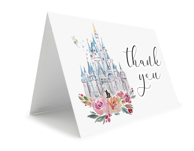May include: A folded white card with a watercolor illustration of a fairytale castle, flowers, and the words "thank you" in black script. The castle is in shades of blue, gray, and white, with a fairy and stars. Pink and orange flowers adorn the bottom.