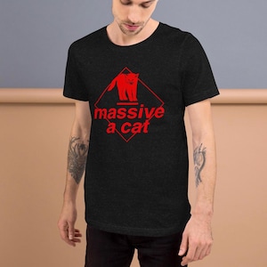 May include: A black t-shirt with a red diamond-shaped warning sign that says "massive a cat" and a red silhouette of a cat inside the sign.