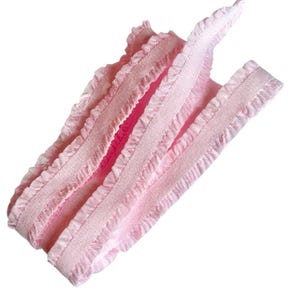 May include: A pile of light pink ribbon with ruffled edges. The ribbon is made of a soft, woven material and is folded over itself. The ribbon is a solid color and appears to be new.