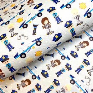 May include: A white fabric with a repeating pattern of blue police cars, police officers, and handcuffs. The pattern is on a light blue background with white polka dots.