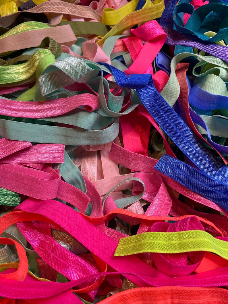 Puede incluir: Un mont&oacute;n grande de gomas el&aacute;sticas para el pelo de colores en varios tonos de rosa, azul, verde, amarillo y naranja. Las gomas el&aacute;sticas para el pelo est&aacute;n hechas de un material suave y el&aacute;stico y son perfectas para sujetar el pelo.