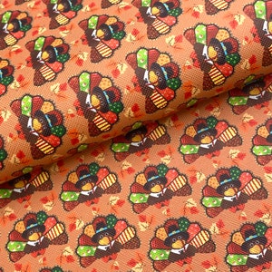 May include: A brown fabric with a repeating pattern of cartoon turkeys wearing pilgrim hats. The turkeys are surrounded by orange, yellow, and green leaves.