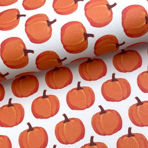 May include: White fabric with a repeating pattern of orange pumpkins. The pumpkins are stylized and have a slightly textured appearance.