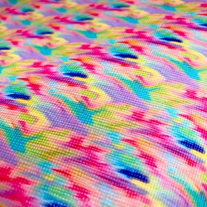 May include: A colorful fabric with a repeating pattern of abstract shapes in shades of pink, blue, green, and yellow. The fabric has a textured, woven appearance.