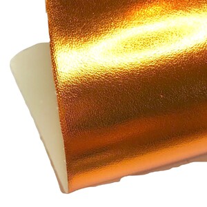 May include: A close-up of a piece of metallic gold fabric with a textured surface.