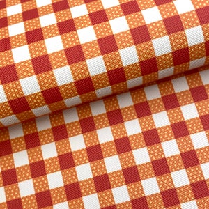 May include: Red and white checkered fabric with a subtle orange pattern. The fabric has a textured surface.