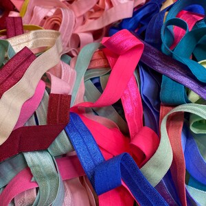 Puede incluir: Un mont&oacute;n de cintas el&aacute;sticas para el pelo de colores en varios tonos de rosa, azul, verde y morado. Las cintas el&aacute;sticas para el pelo est&aacute;n hechas de un material suave y el&aacute;stico y son perfectas para sujetar el pelo.