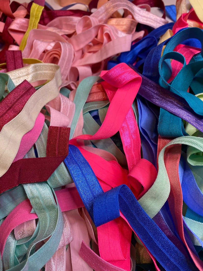 Puede incluir: Un mont&oacute;n de cintas el&aacute;sticas para el pelo de colores en varios tonos de rosa, azul, verde y morado. Las cintas el&aacute;sticas para el pelo est&aacute;n hechas de un material suave y el&aacute;stico y son perfectas para sujetar el pelo.