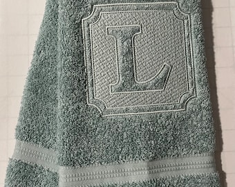 Toalla de mano con monograma en relieve.