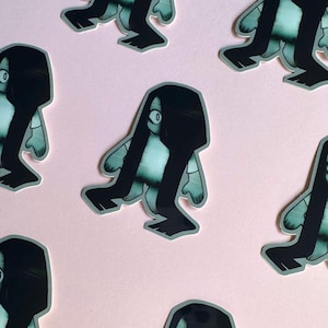 May include: A set of five stickers featuring a cartoon character with long black hair and a white dress. The character has a single large eye and is depicted with long, thin legs. The stickers are printed on a clear background.